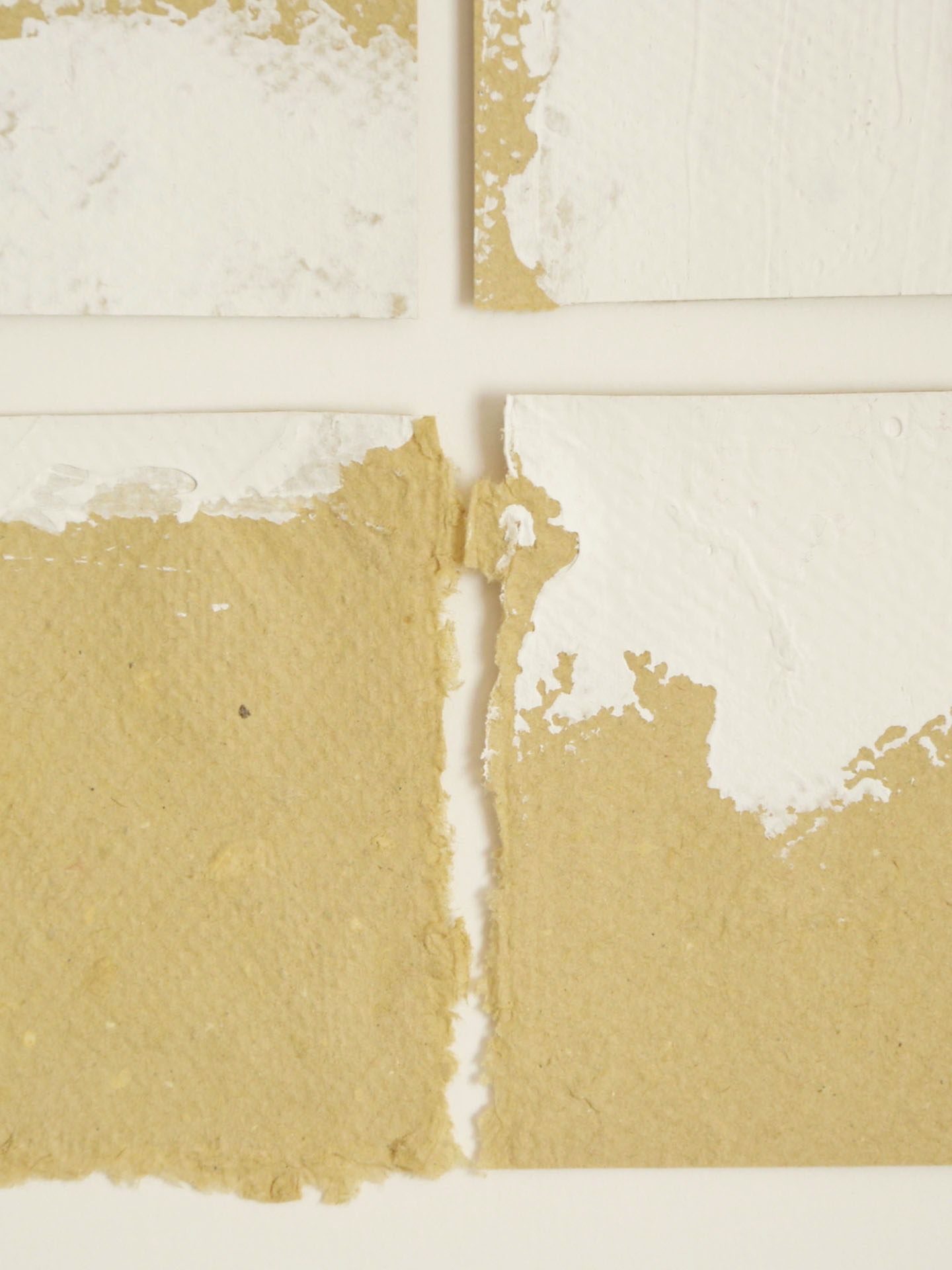 Detalle macro de la obra "Deconstruyendo I" que muestra el rasgado artesanal de dos papeles ocre y la aplicación de pintura blanca matérica. Se aprecia la fibra del papel y la intersección de las formas en La Oculta Gallery.