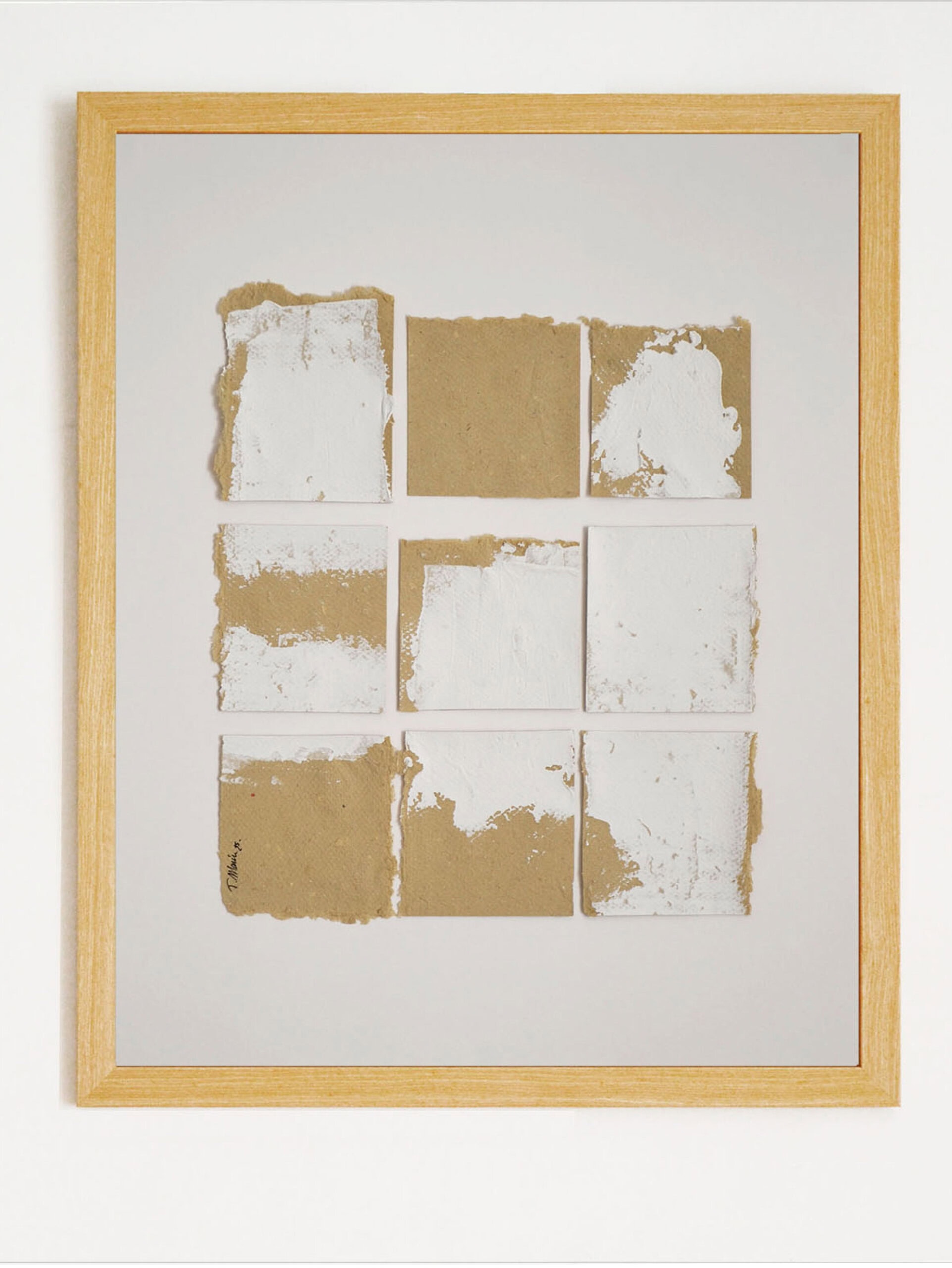 Obra de arte original "Deconstruyendo I" de la serie Materia. Cuadrícula de nueve piezas de papel artesanal ocre con intervenciones de pintura blanca matérica, presentada en marco de madera clara con paspartú blanco y firma del artista.