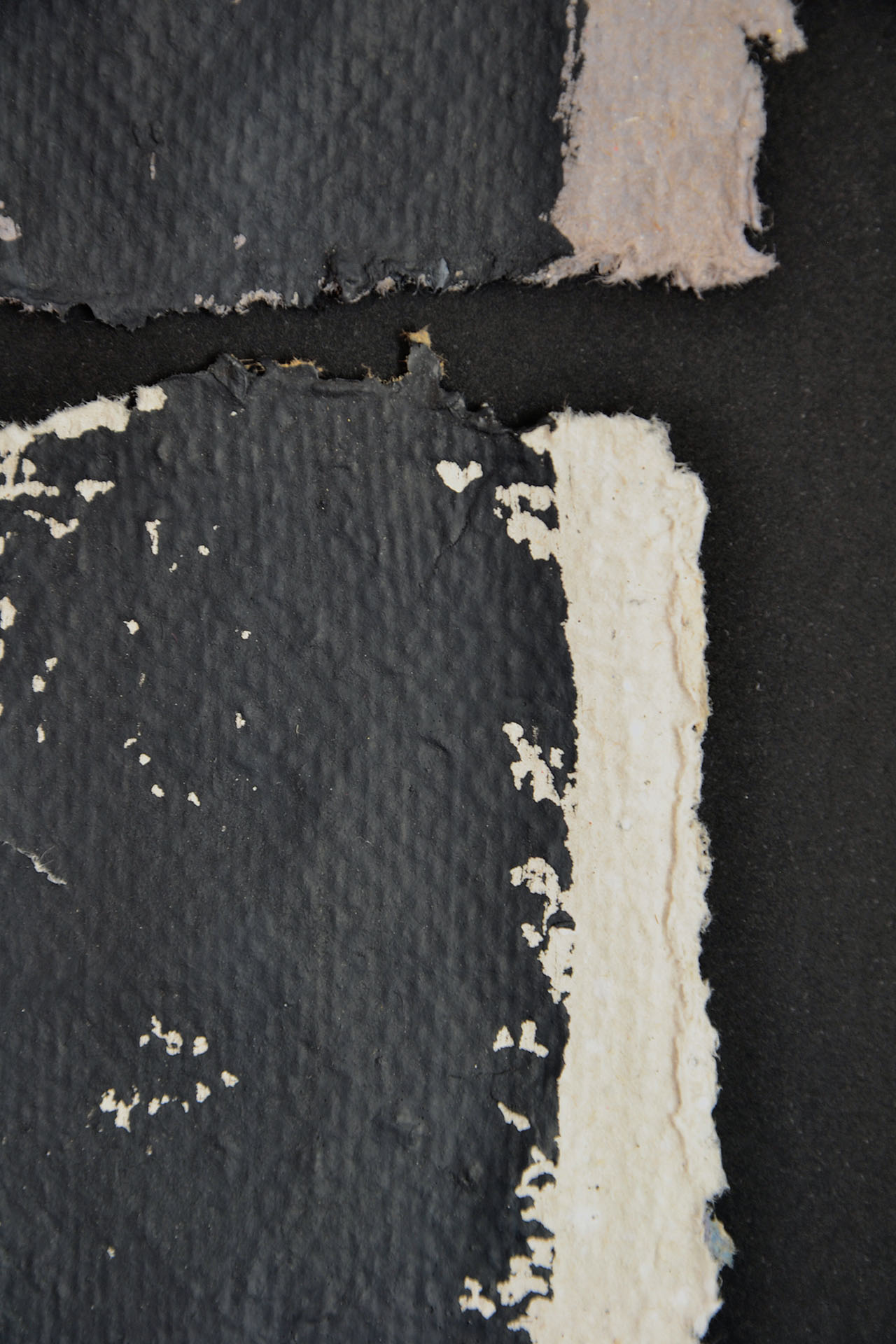 Detalle macro de la obra "Deconstruyendo III" donde se aprecia la textura del papel artesanal color crema y el relieve de la pintura negra mate. Primer plano de los bordes orgánicos y la porosidad del soporte en La Oculta Gallery.