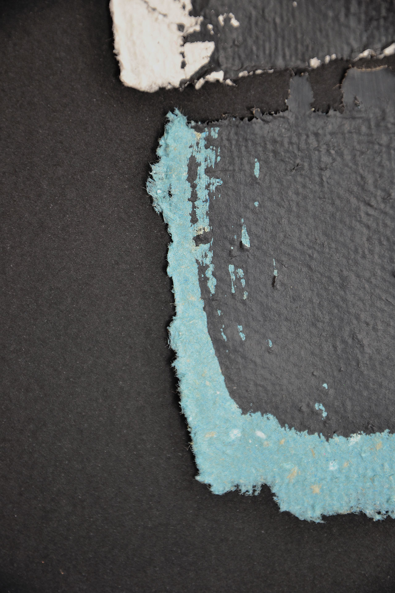Primer plano de la obra "Deconstruyendo III" que muestra la textura desflecada del papel artesanal azul turquesa y el relieve matérico de la pintura negra en el borde. Se aprecia el contraste de materiales y la profundidad del pigmento en La Oculta Gallery.