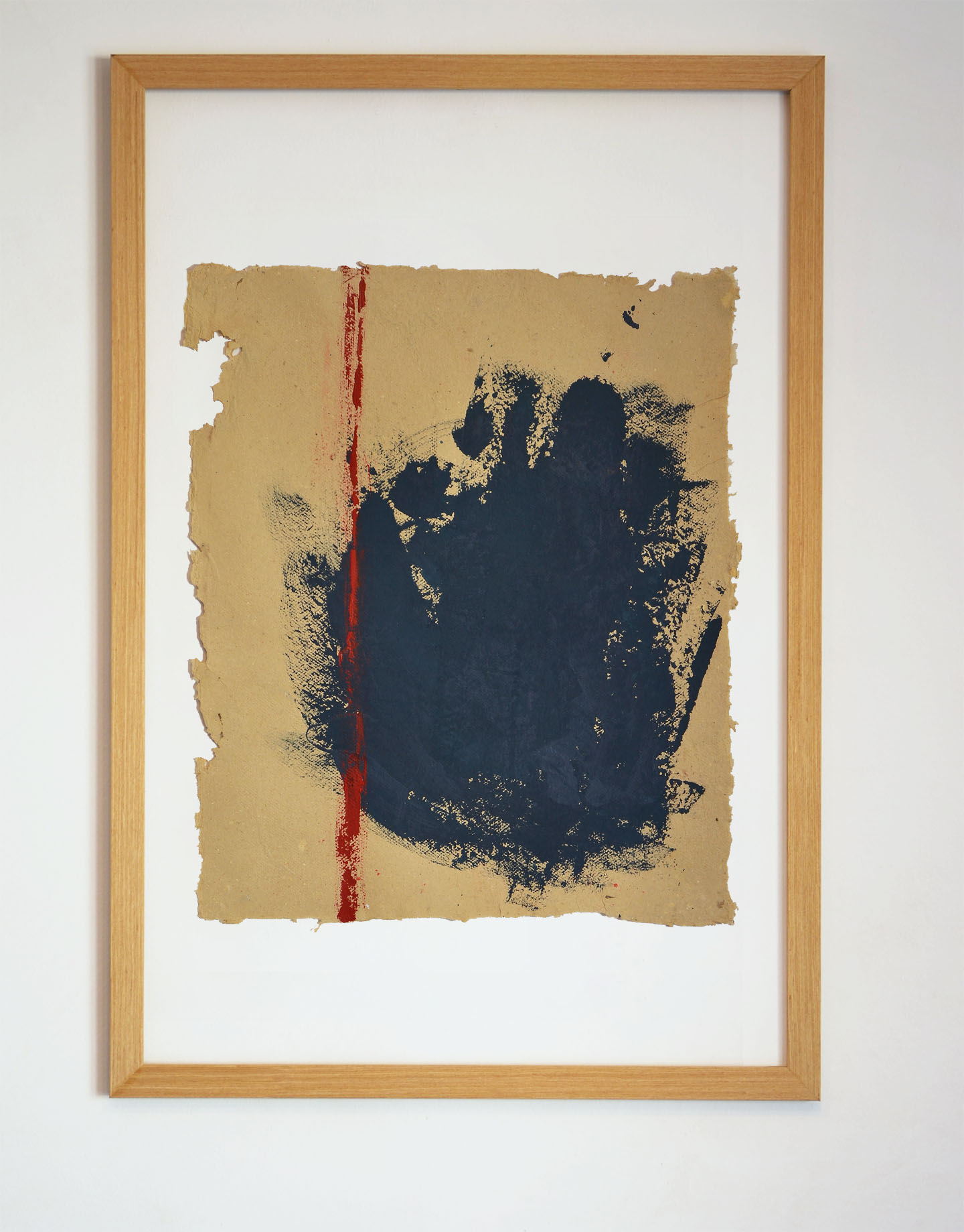 Obra original "Desdibujando el límite" de T. Marín enmarcada en madera natural. Arte matérico con mancha azul oscuro y trazo rojo sobre papel artesanal de borde irregular en La Oculta Gallery.
