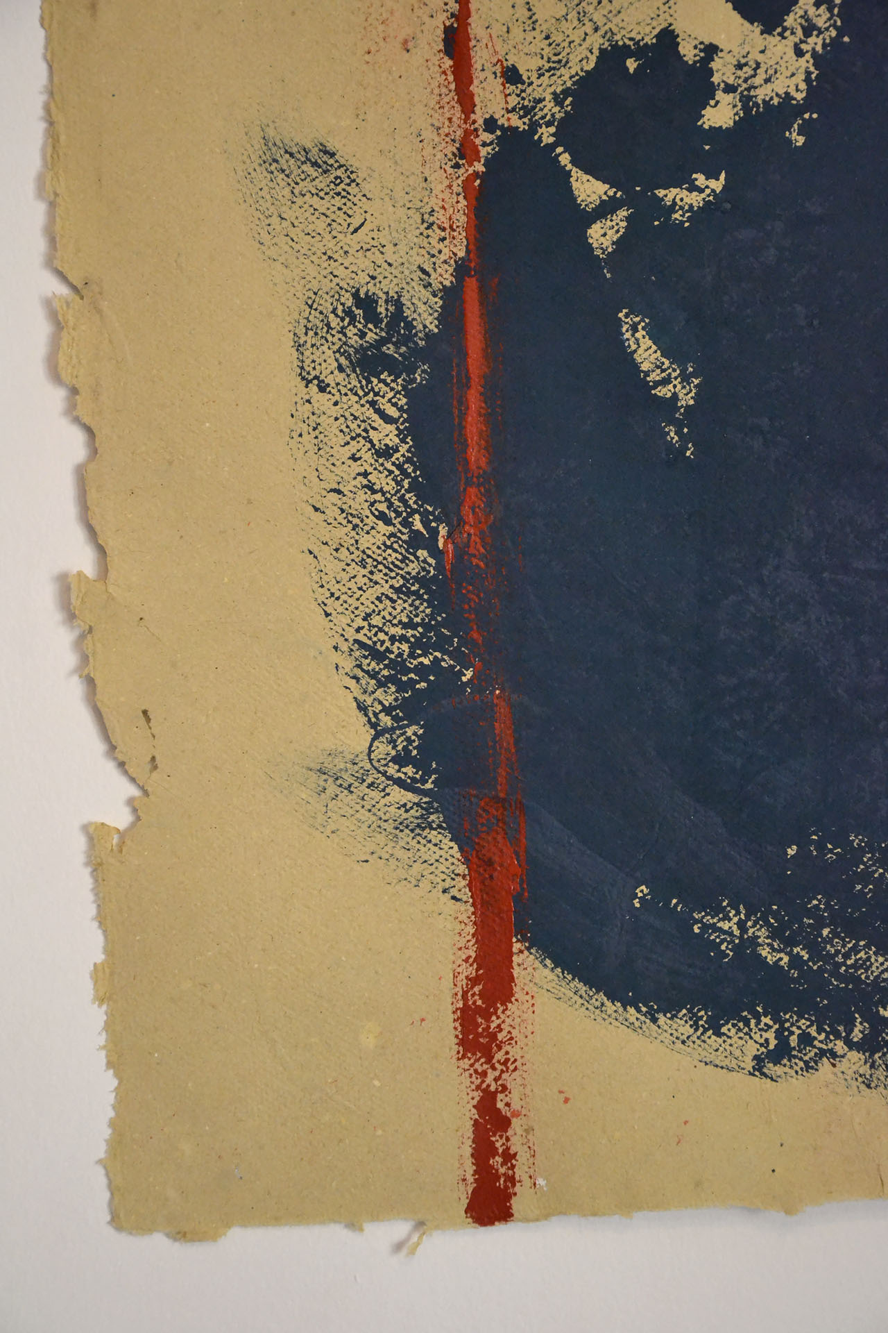 Primer plano detallado de la obra "Desdibujando el límite". Se observa la mancha azul profundo con textura de lienzo, el trazo vertical de pintura roja con relieve y el borde orgánico y desgarrado del papel artesanal ocre en La Oculta Gallery.