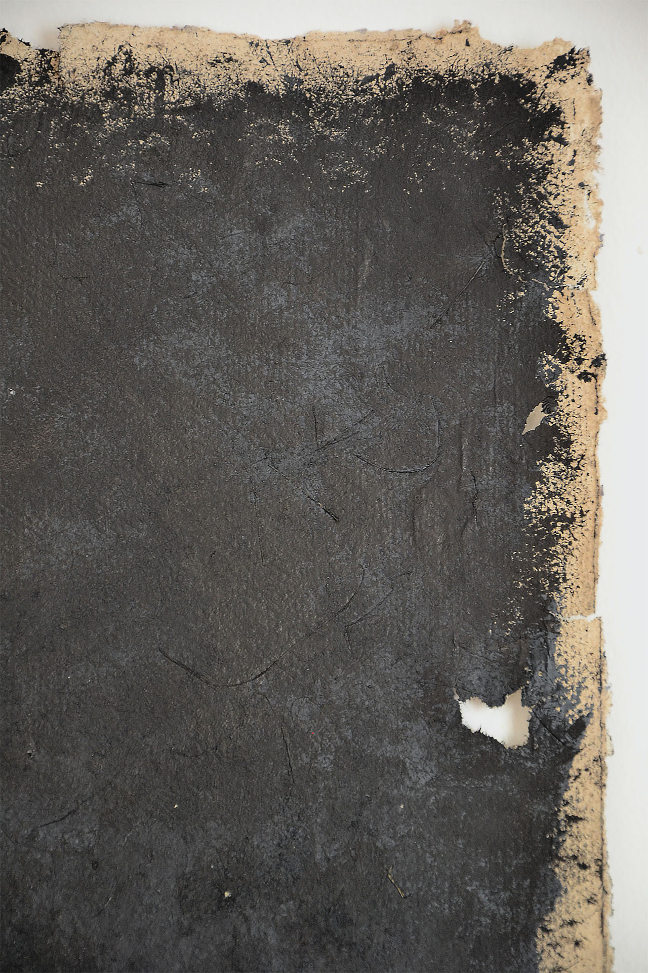 Obra original "Huecos y Textura I" de la serie Lines, presentada en marco de madera natural con paspartú blanco. Arte contemporáneo matérico con una gran mancha negra y una fina línea vertical central sobre papel artesanal.